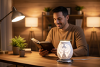 Hispanic man reading Bible at desk with White Angel Wings Touch Fragrance Oil Burner glowing beside him