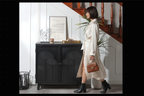 Modern black accent cabinet in entryway with woman