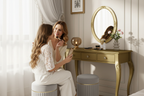 Mom and teen daughter at gold vanity dressing table
