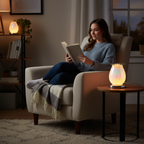 Young woman reading a book with White Drizzles lamp glowing beside her