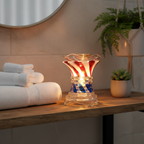 Crystal glass fragrance oil warmer glowing on bathroom vanity